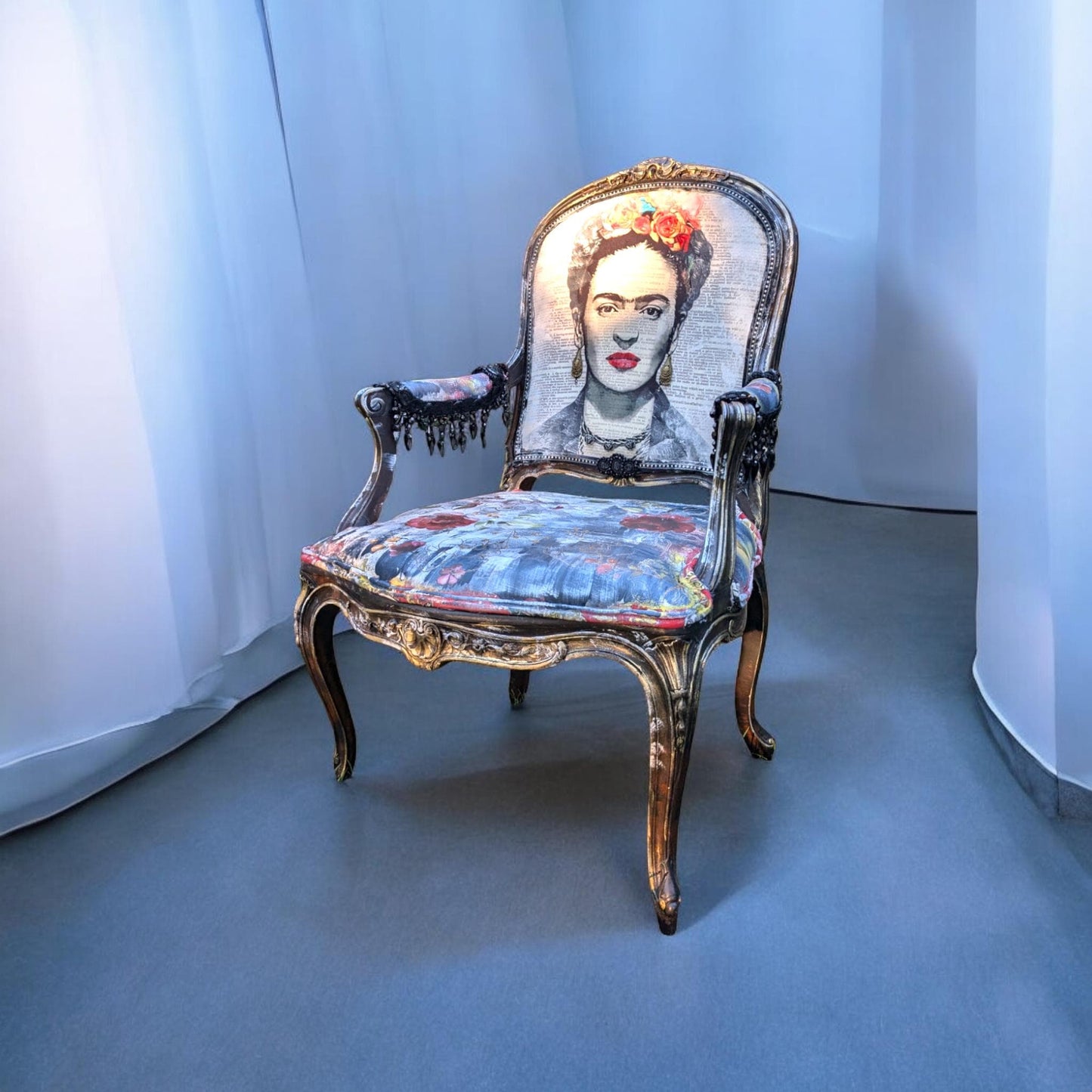 Bring style and character to your home decor with this one-of-a-kind Frida Kahlo vintage French upcycled chair. The chair frame is made of solid wood, painted black, and decorated with gold wax. Chair decsorated with extar large black tassels.