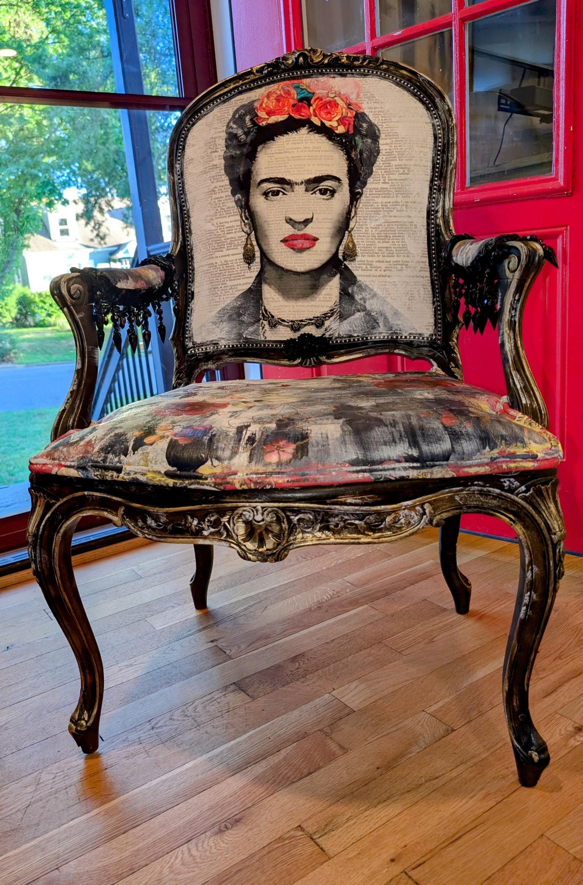 Bring style and character to your home decor with this one-of-a-kind Frida Kahlo vintage French upcycled chair. The chair frame is made of solid wood, painted black, and decorated with gold wax. Chair decsorated with extar large black tassels.