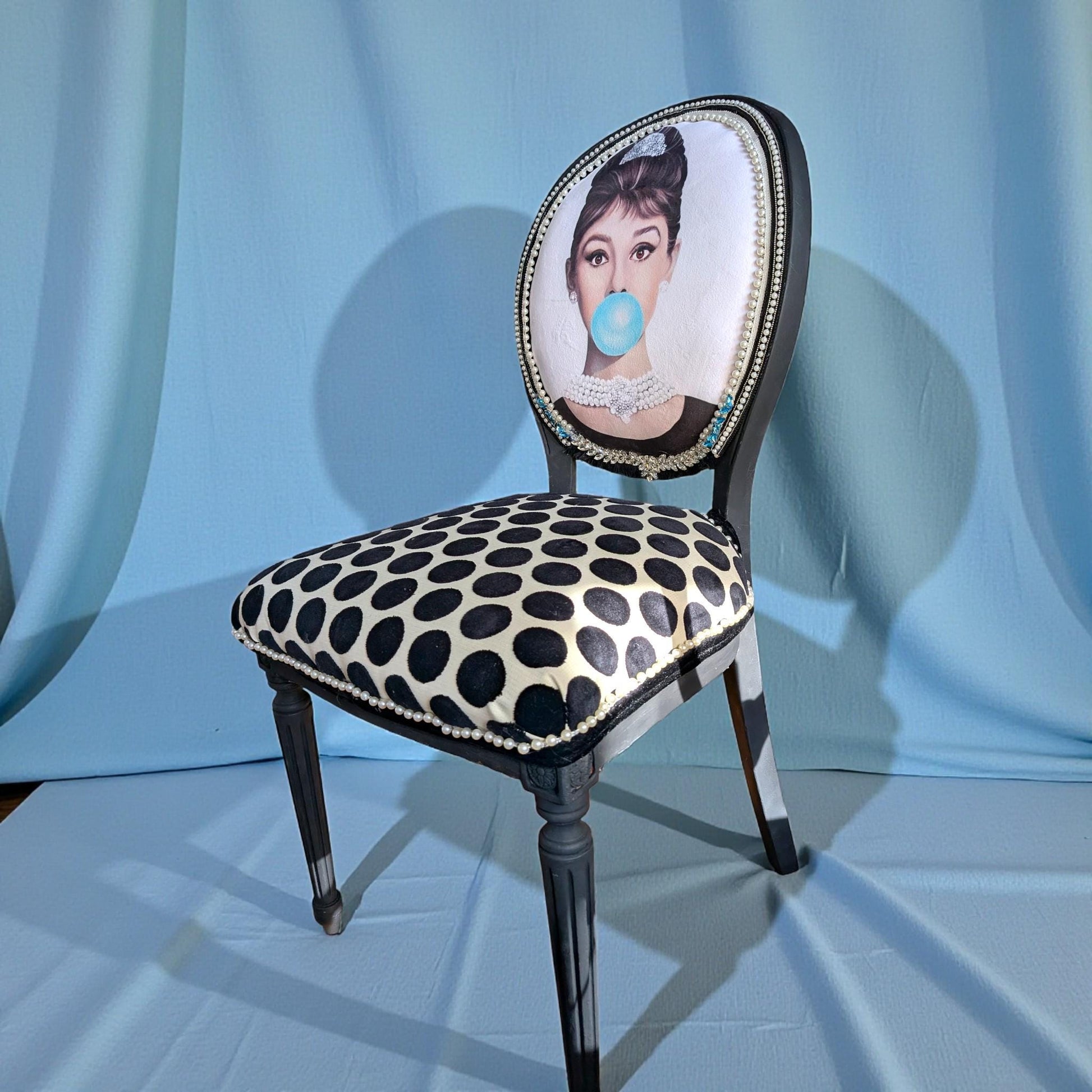 Audrey Hepburn Vanity Chai. Hand-Painted Hollywood Decor. Step into timeless elegance with the Audrey Hepburn Vanity Chair Retro Painted Furniture Pop Art Design Old Hollywood Decor Glamorous Makeup Seat. This uniquely crafted piece combines classic Hollywood charm with vibrant pop art flair, making it a standout addition to your vanity or dressing area. Designed for those who appreciate both style and comfort, this chair offers a nostalgic yet modern touch that elevates any space.