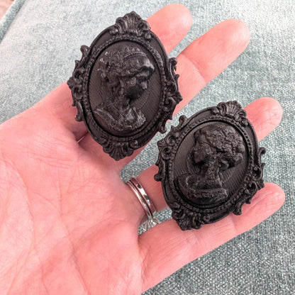Add a touch of gothic elegance to your furniture with this stunning 3D-printed Cameo Cabinet Drawer Pull. Designed to elevate your cabinetry, this drawer knob combines vintage charm with modern craftsmanship, making it perfect for furniture hardware, wardrobe handles, kitchen hardware, and bathroom remodels. Crafted with attention to detail, this gothic-inspired drawer pull features intricate carved accents that evoke a sense of timeless sophistication.