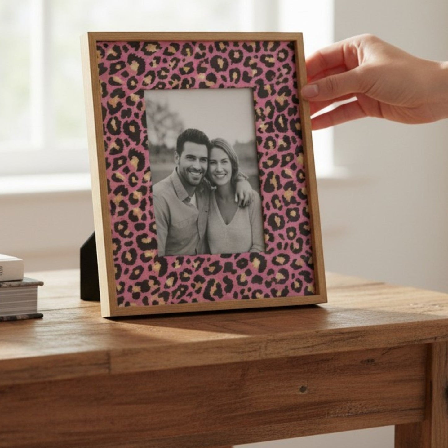 Pieces Reclaimed pink leopard print decoupage tissue paper applied to a wooden picture frame on a rustic table