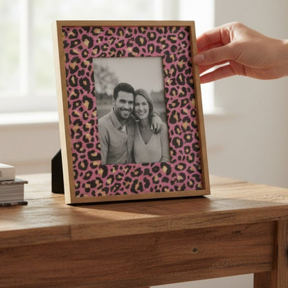Pieces Reclaimed pink leopard print decoupage tissue paper applied to a wooden picture frame on a rustic table