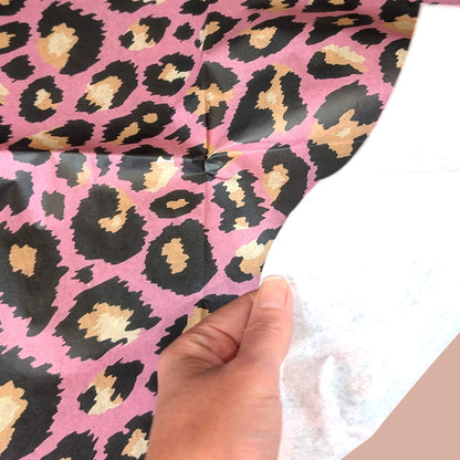 Pieces Reclaimed pink leopard print tissue paper for decoupage and furniture upcycling held by a hand