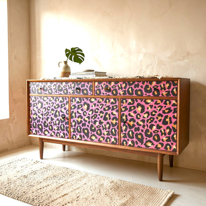Pieces Reclaimed pink leopard print decoupage paper applied to a mid-century modern wooden sideboard cabinet