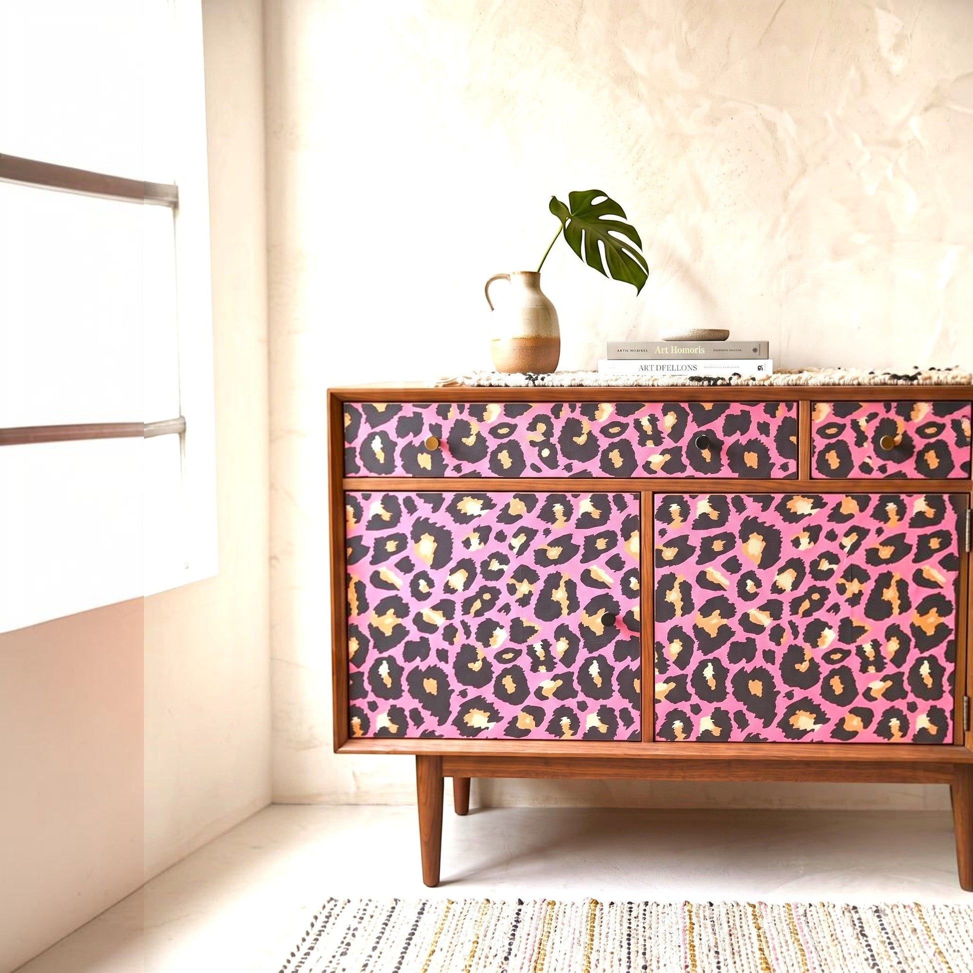 Pieces Reclaimed pink leopard print decoupage paper applied to a mid-century modern wooden sideboard cabinet
